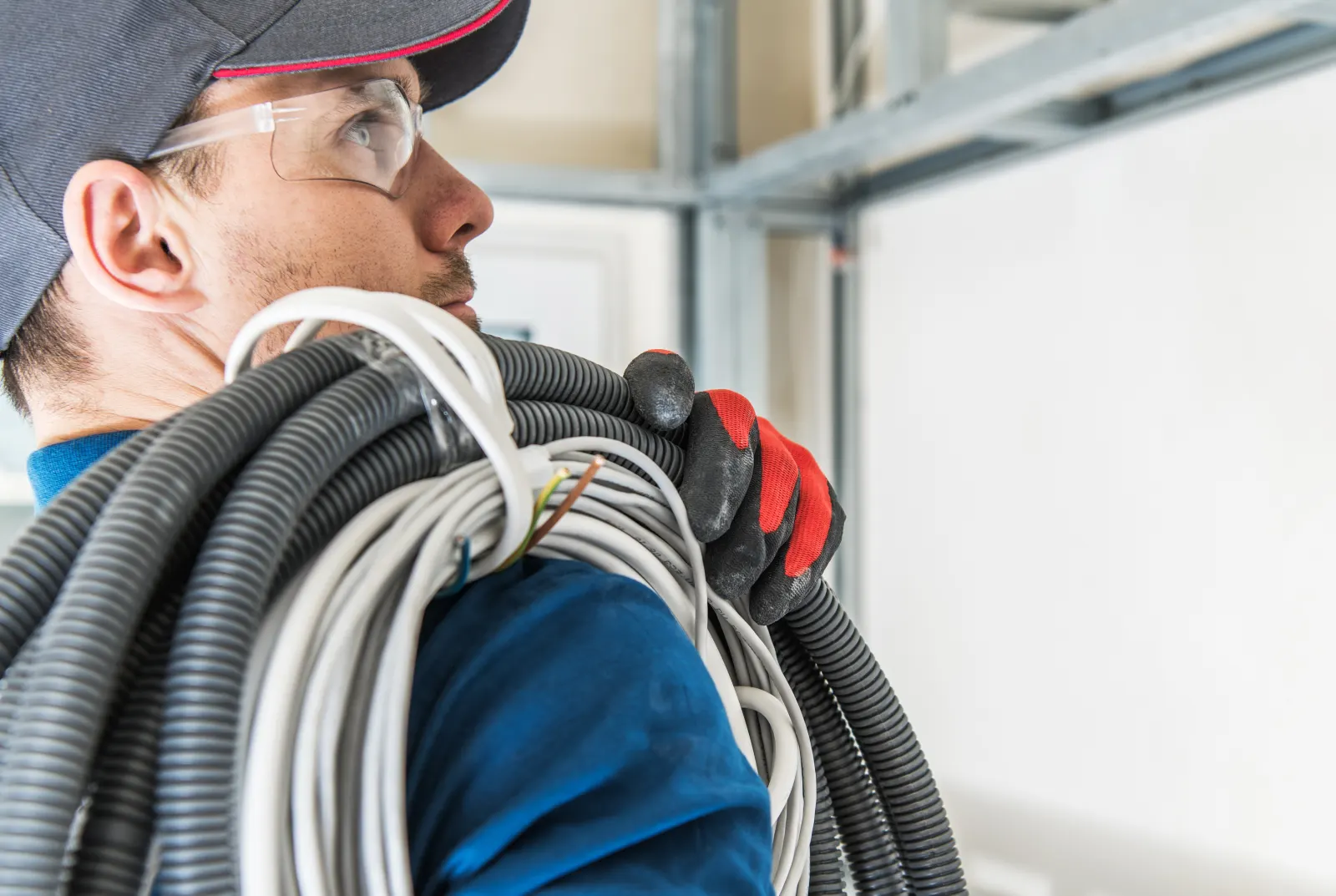 Electrician with cables and protective gear